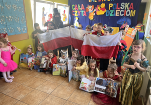 Dzieci przebrane za postacie z bajek, trzymające flagę Polski