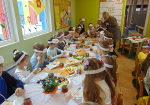 Dzieci spożywają śniadanie wielkanocne.